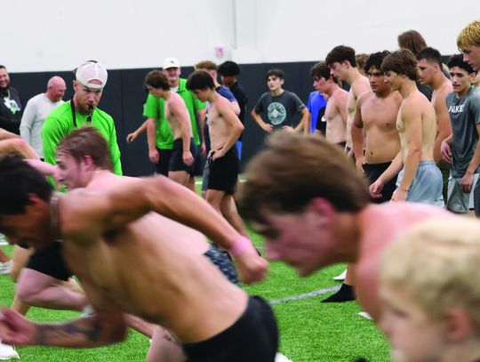 Offensive coordinator Colton Brewer watches the Bulldogs to make sure they start behind the line as they begin their 10-yard sprint on the first day of summer strength and conditioning June 2.