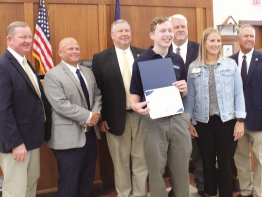 The Burnet County commissioners acknowledge Marble Falls High School senior Henry Vanicek as he holds the Pedernales Electric Cooperative Certificate of Appreciation for his participation in the 2024 Youth Tour Delegates Program. From left, Pct. 1 Commissioner Jim Luther Jr., Pct. 2 Damon...