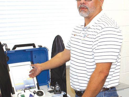 Raymond V. Whelan/ bulletin Burnet County Elections Administration Assistant Chris Guzman explains how voters can operate a Hart Civic Inc. “ballot- marking touch pad” during a poll worker voting session April 9 in Burnet at the Texas AgriLife Extension.