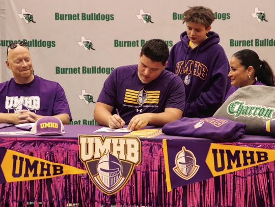 Johnny Charron will play football for the University of Mary Hardin-Baylor after signing with the Crusaders while parents John (left) and Ivette and little brother Luke (standing) look on. Photos by Martelle Luedecke/Luedecke