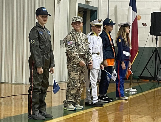 Pictured, from left, are BCISD students Rory Blasienz, Easton Floyd, Aiden Brownlee, Zane Munger and Brooke Kiley, who represented members of the armed forces at the Veterans Day program.