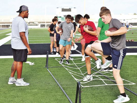 BHS Coach Quentin Rhoder watches over footwork drills during last week’s football camp at BHS. Around 150 kids participated in the event. Wayne Craig/Clear Memories