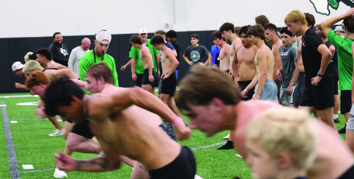 Offensive coordinator Colton Brewer watches the Bulldogs to make sure they start behind the line as they begin their 10-yard sprint on the first day of summer strength and conditioning June 2.