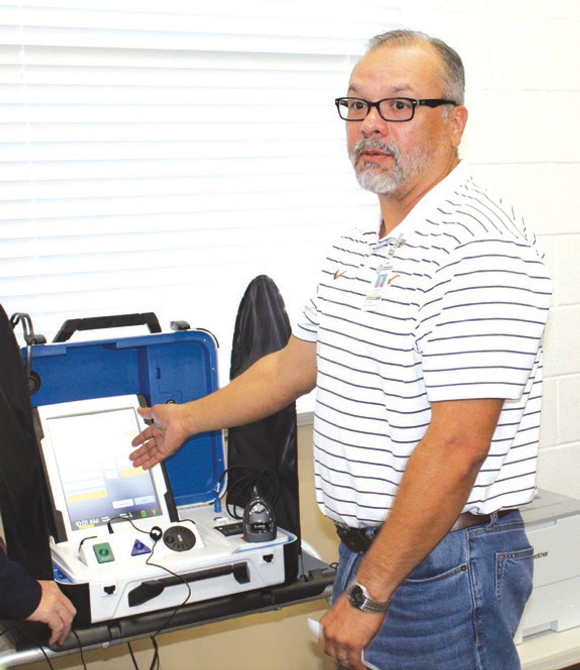 Raymond V. Whelan/ bulletin Burnet County Elections Administration Assistant Chris Guzman explains how voters can operate a Hart Civic Inc. “ballot- marking touch pad” during a poll worker voting session April 9 in Burnet at the Texas AgriLife Extension.