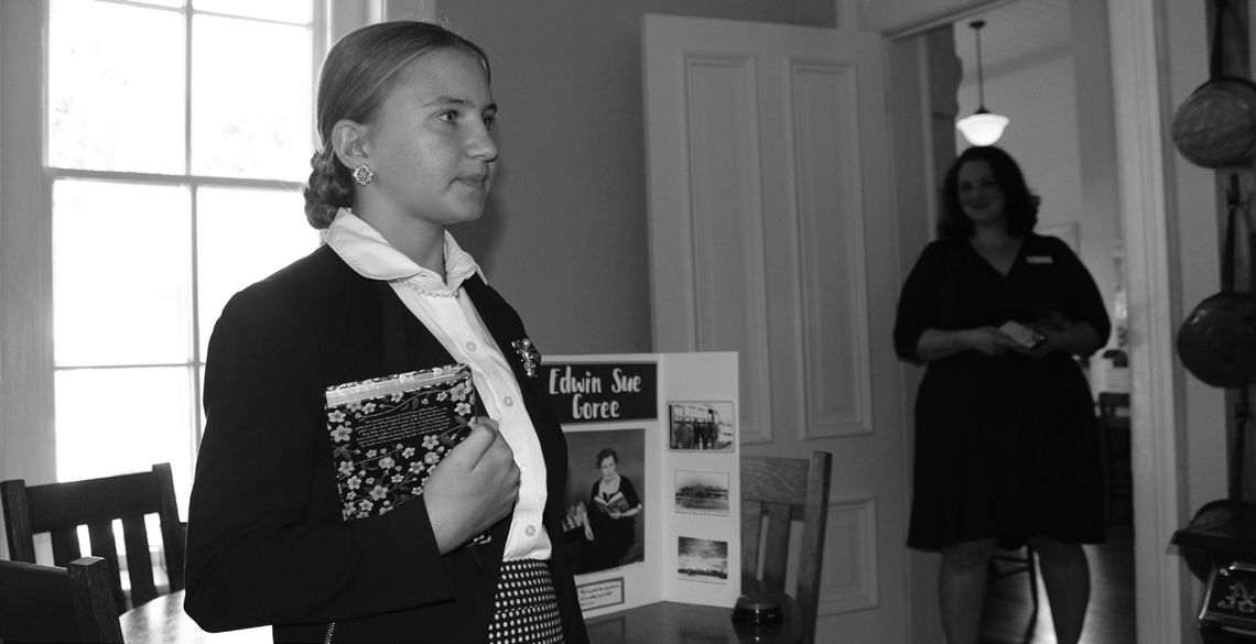 Burnet Home School student Sara Beth Nichols, 13, portrayed Edwin Sue Goree (pictured behind Nichols), the first Burnet Library Director 75 years ago, while current Herman Brown Free Library Director Florence Reeves observes. Photos by Raymond V. Whelan/Bulletin