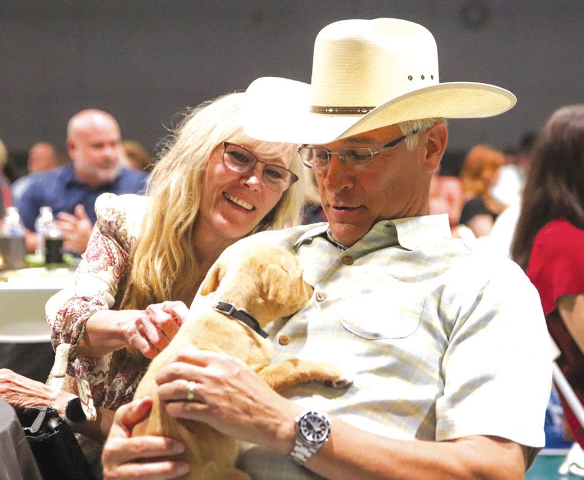 Kathy and Alan Trevino, owner of event title sponsor Sentry Security & Investigations, were charmed by Scotty on April 26 at the Wags to Riches, which raised money for the Hill Country Humane Society. Find more photos on Page 14.